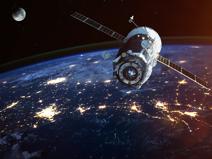 Space satellite circles Earth at night